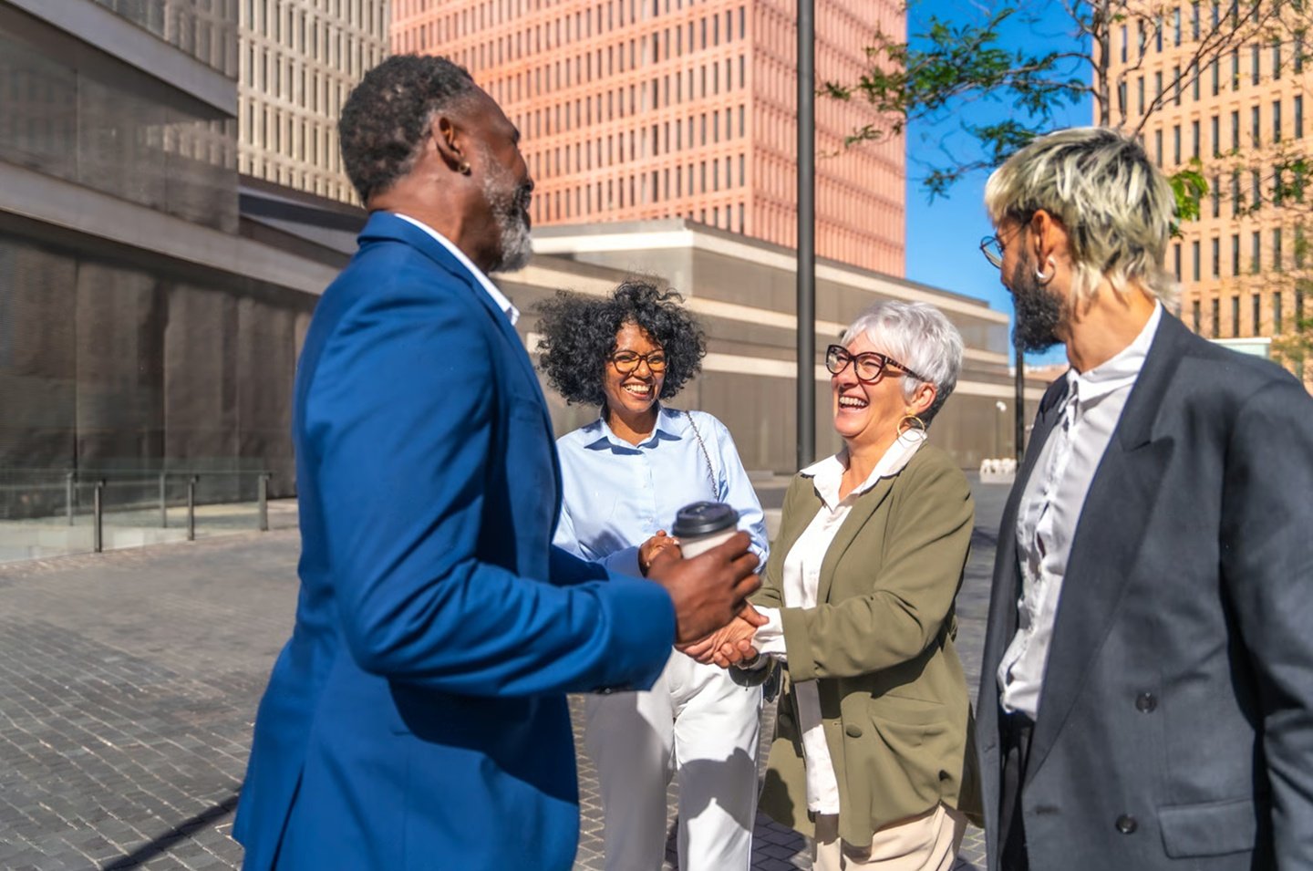 people smiling and shaking hands in big city